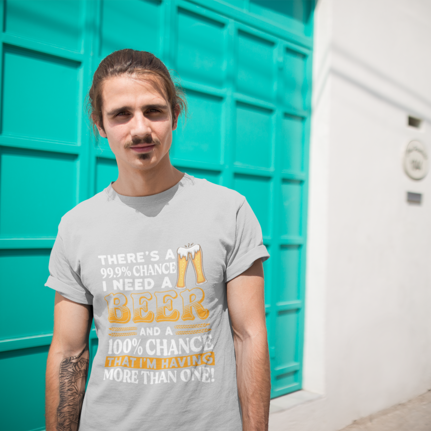 Man wearing a gray t-shirt with text standing in front of teal storage units.