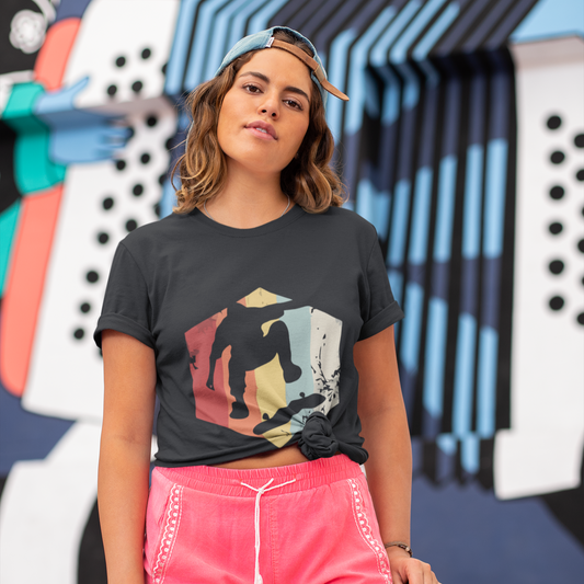 Person wearing a black t-shirt with a colorful graphic and pink shorts, standing in front of a vibrant mural.