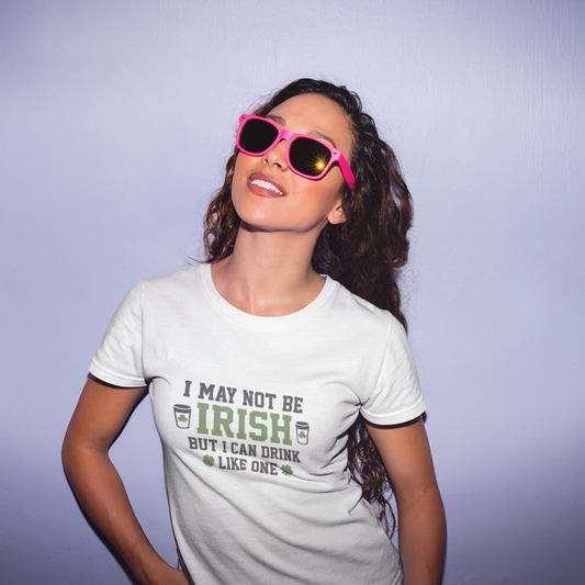 Woman wearing a t-shirt with a humorous design and pink sunglasses against a plain background