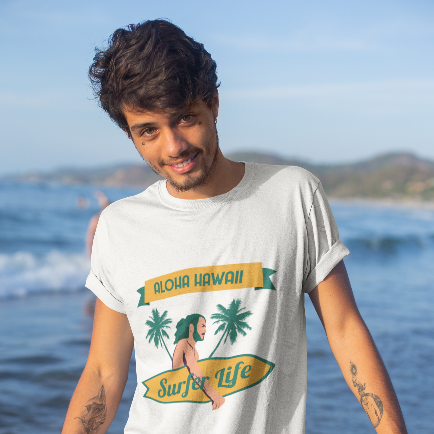 Man wearing a 'Surfer Life' t-shirt by the ocean
