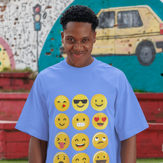 Person wearing a blue t-shirt with yellow emoji designs in front of a colorful mural.