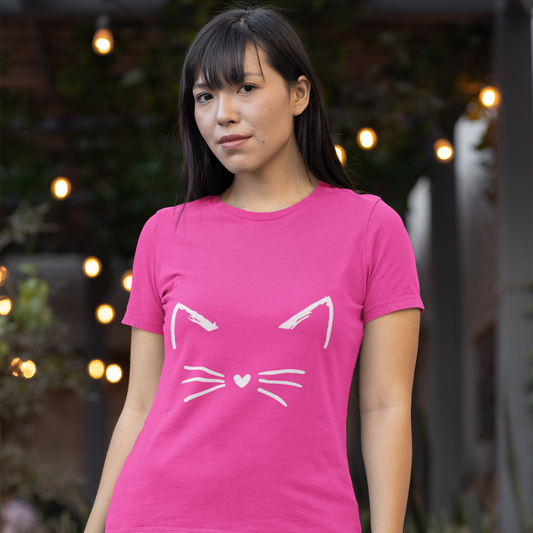 Woman wearing a pink t-shirt with a cat face design outdoors.