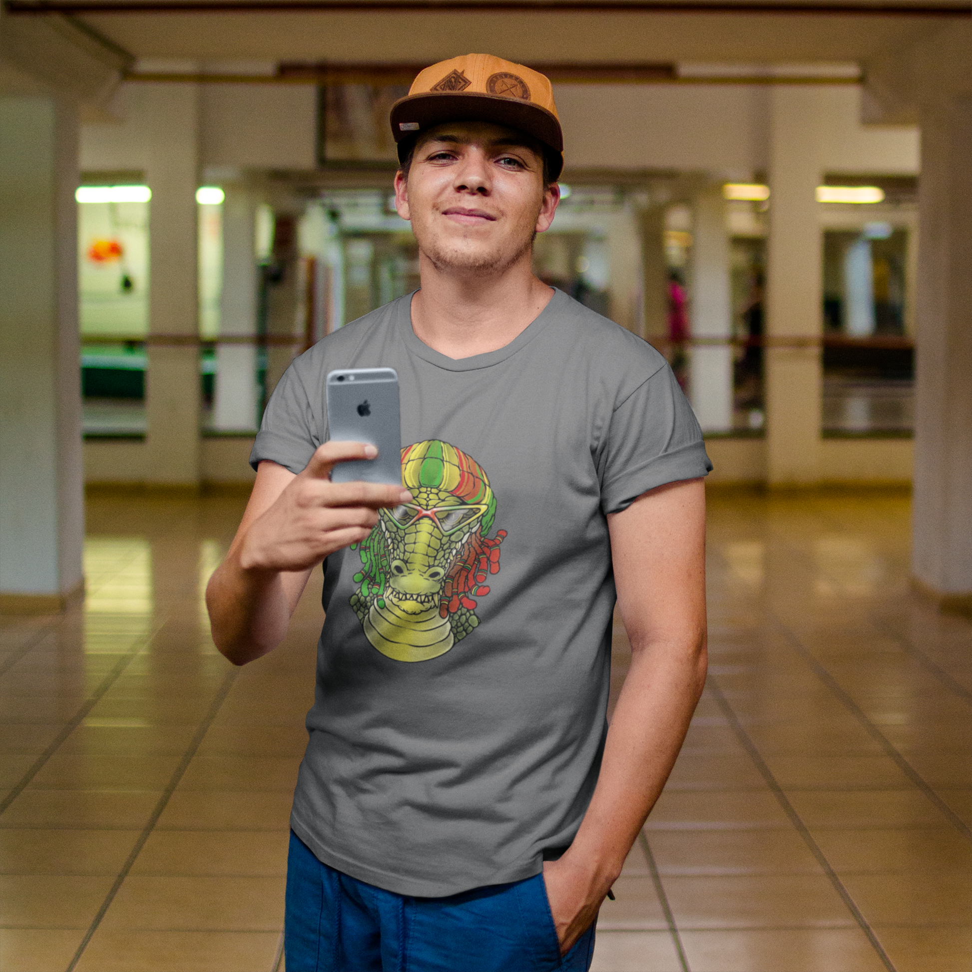 Person wearing a gray t-shirt with a colorful graphic design, holding a phone in an indoor setting.