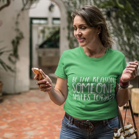 Woman wearing a green t-shirt with a motivational quote, standing in an outdoor setting.