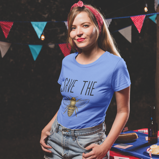 Woman wearing a blue 'Save the Bees' t-shirt at an outdoor event with bunting in the background.