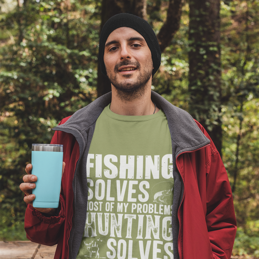 Man in a forest holding a blue tumbler, wearing a green shirt with text.