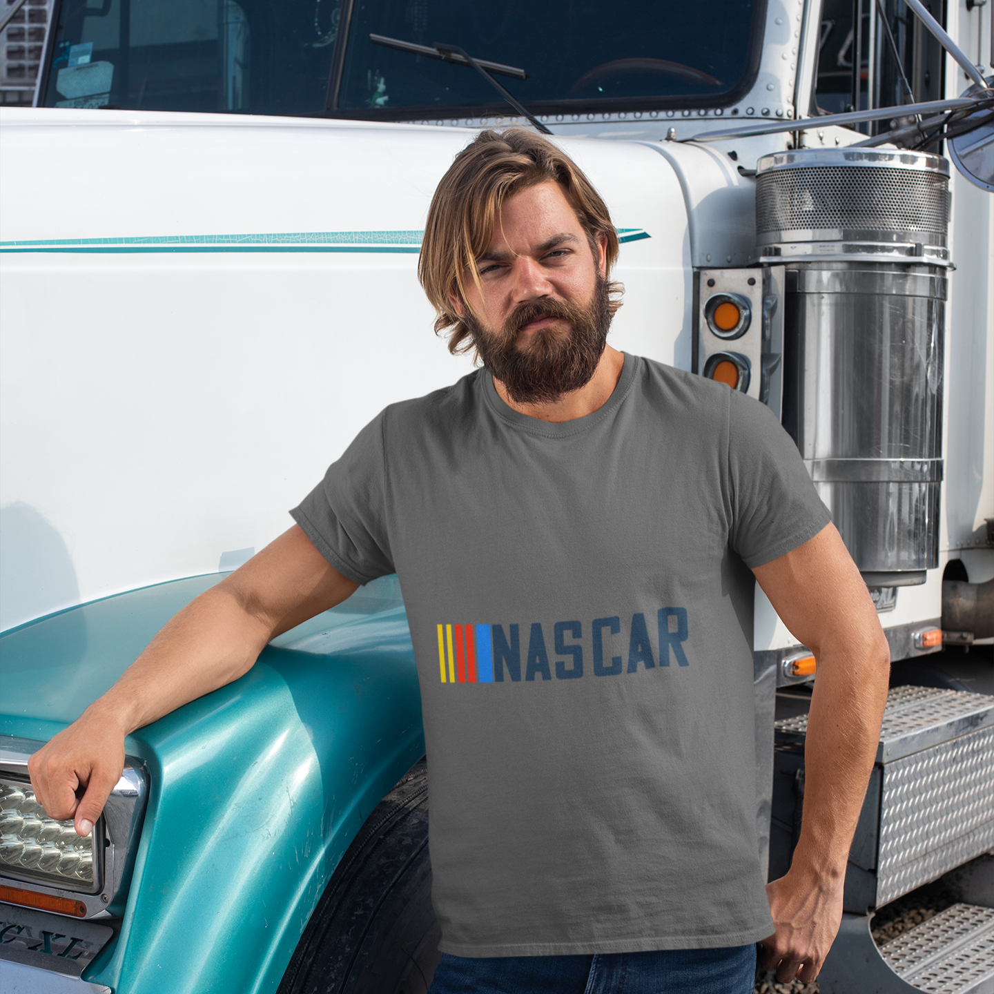 Man wearing a NASCAR t-shirt standing next to a large truck.