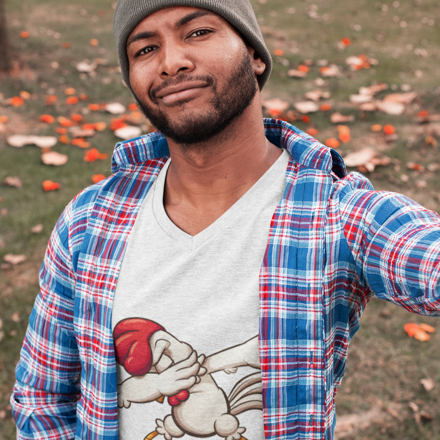 Man wearing a plaid shirt over a graphic t-shirt with a cartoon character, standing outdoors.