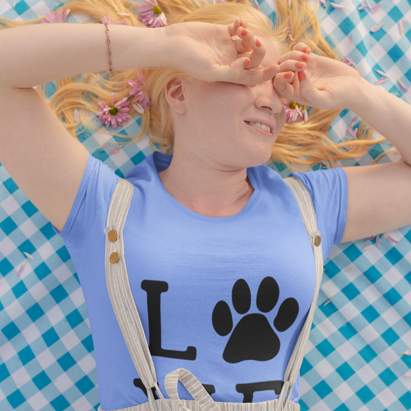 Person wearing a blue shirt with a paw print design on a checkered background