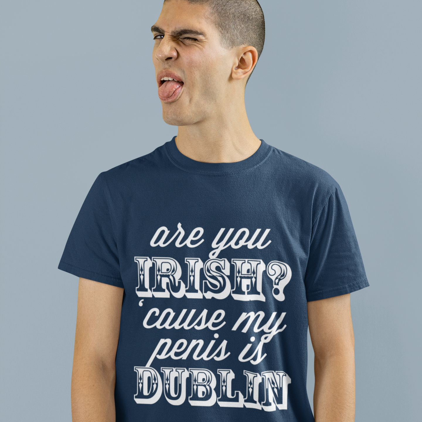 Man wearing a navy blue t-shirt with humorous text on a gray background