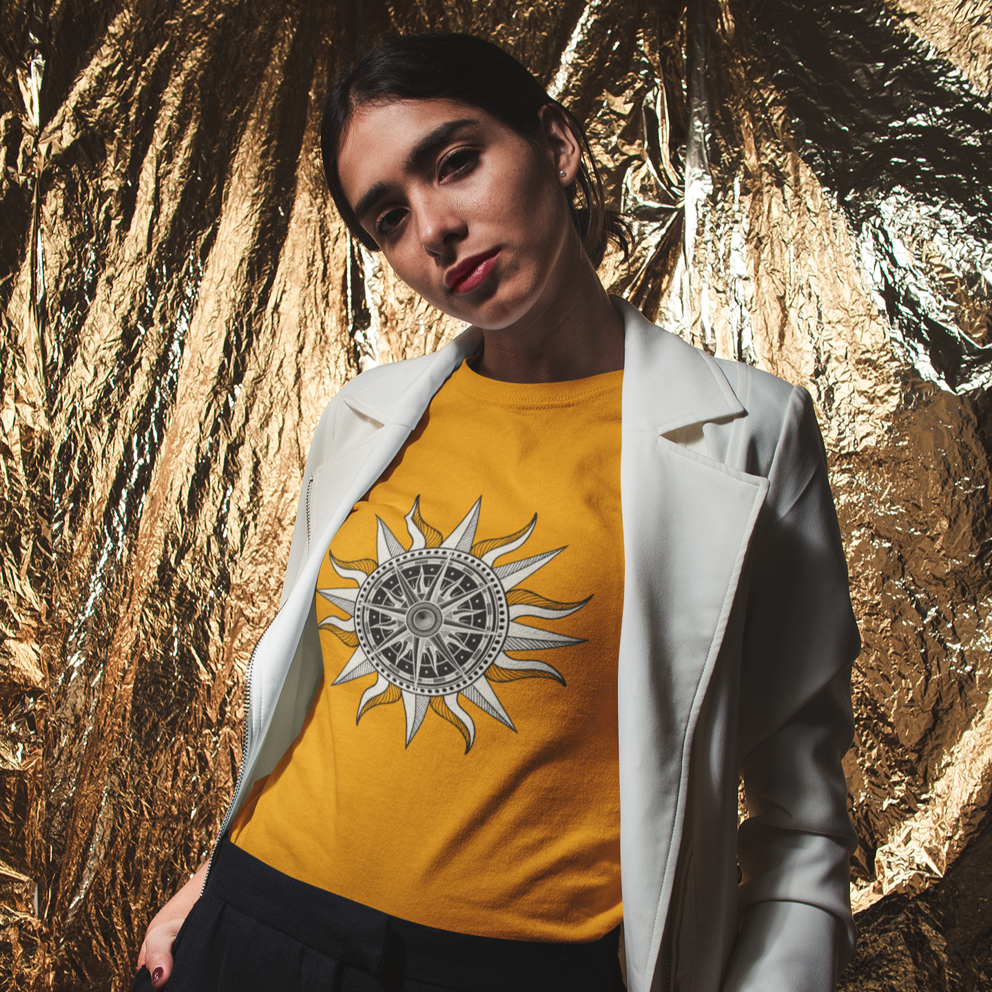 Person wearing a yellow t-shirt with a sun design against a gold leaf background