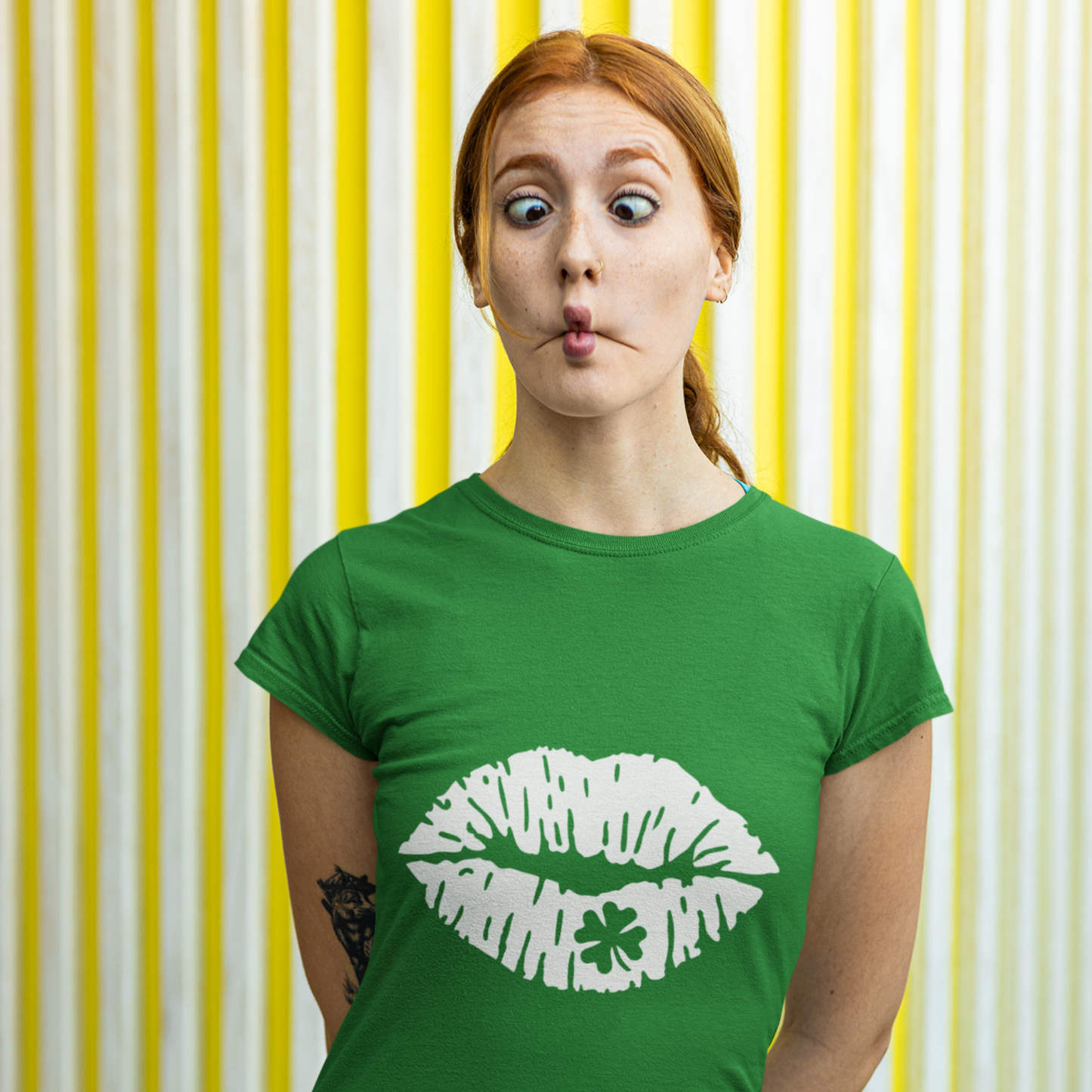 Person wearing a green t-shirt with white lips design against a yellow and white striped background