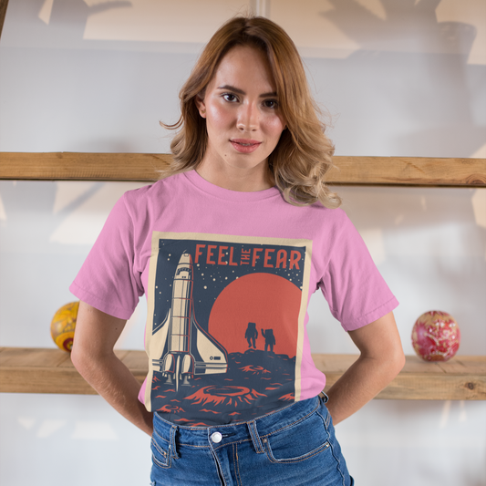 Woman wearing a pink t-shirt with a graphic design and text, standing indoors.
