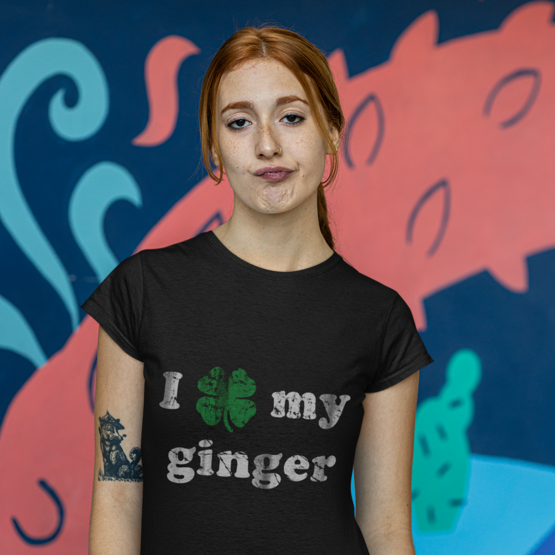 Person wearing a black t-shirt with 'I love my ginger' text in front of a colorful mural.