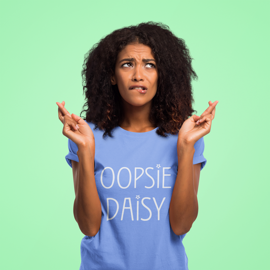 Woman wearing a blue 'OOPSIE DAISY' t-shirt against a green background